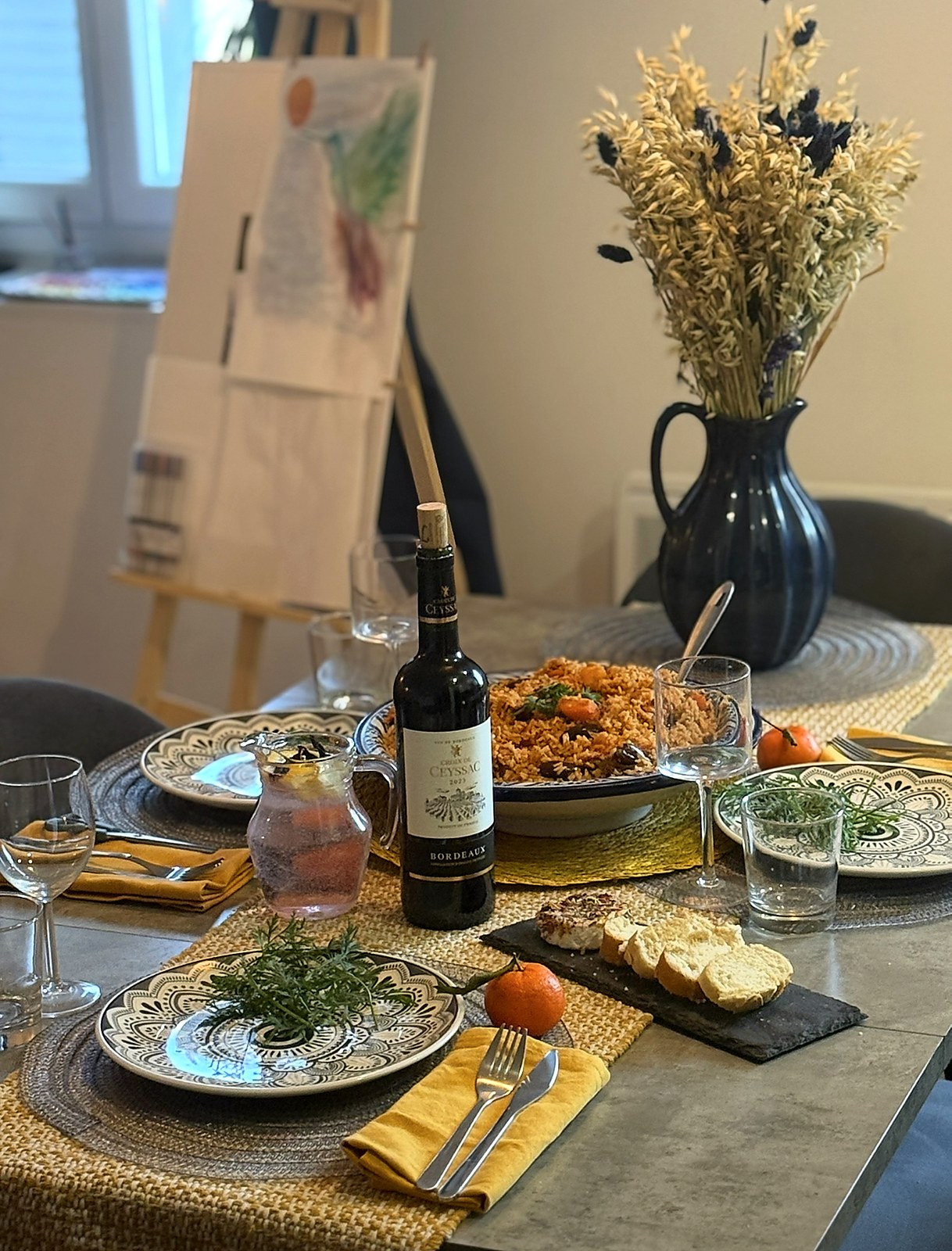 French table set with Bordeaux and paella
